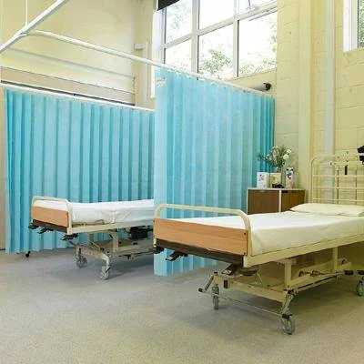 Blue blackout hospital curtains between two patient beds in ward
